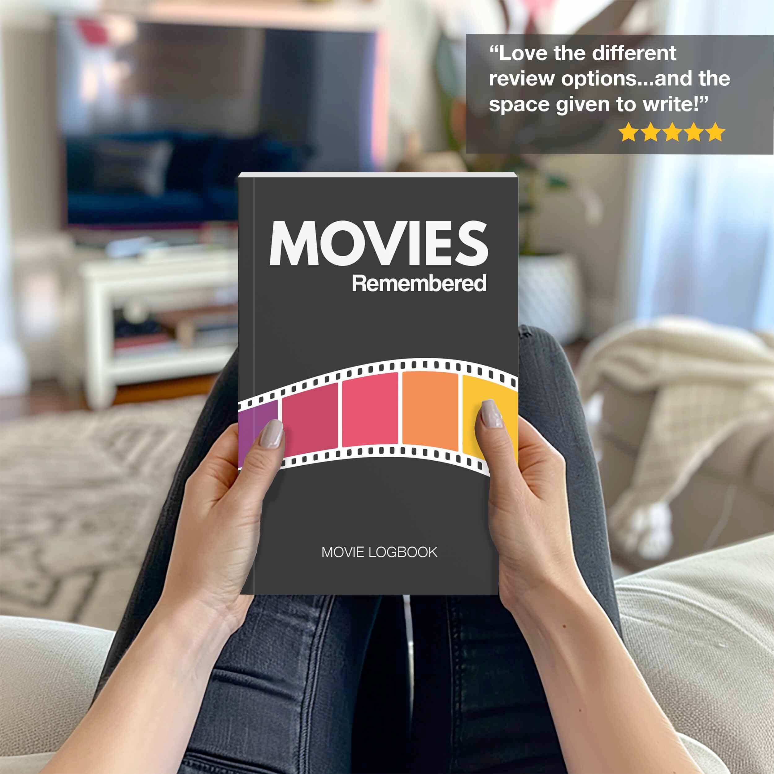 A person holding the Movies Remembered movie logbook, designed for cataloging film reviews and experiences.