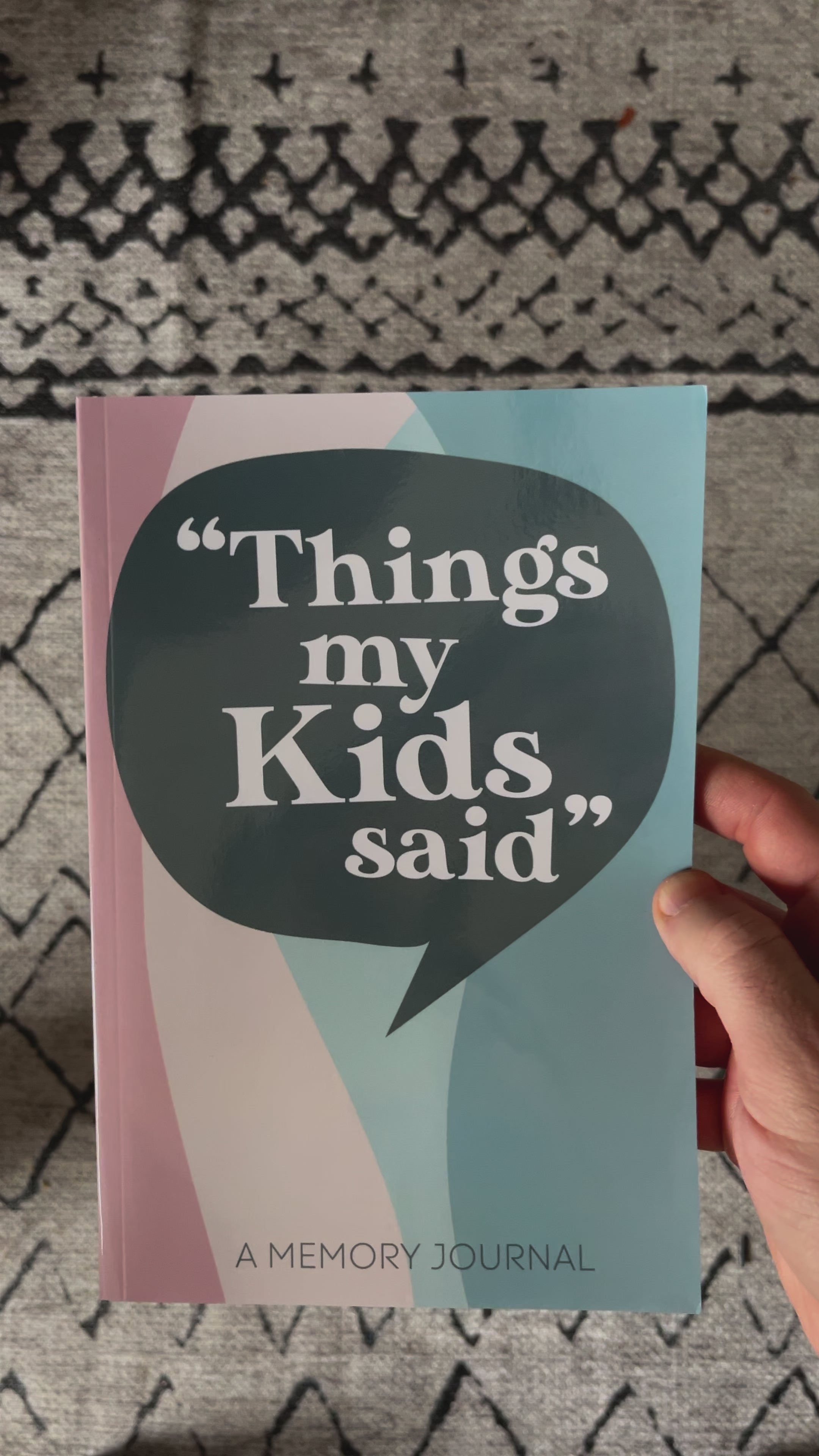 Cover of 'Things My Kids Said' memory journal held in hand, featuring colorful speech bubble design.