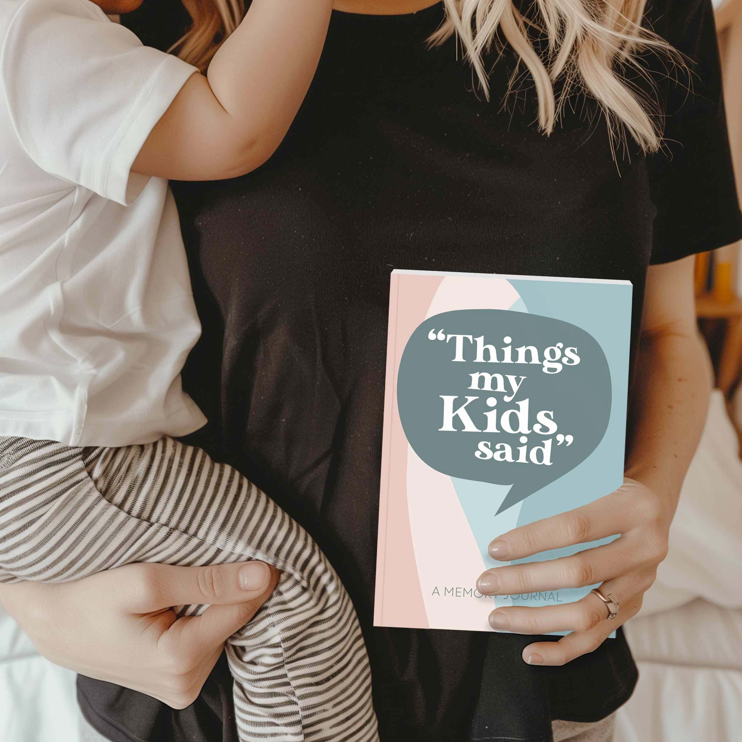 A parent holding the 'Things My Kids Said' memory journal with their child, showcasing a heartfelt moment.